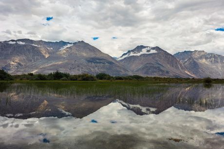 Majestic mountains of Nubra Valley, perfectly reflected in the still waters, creating an inverted mirror image
